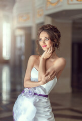 Close-up portrait of a luxurious bride in a wedding dress in the morning in a chic interior. wedding makeup and hairstyle. Beautiful face with big green eyes