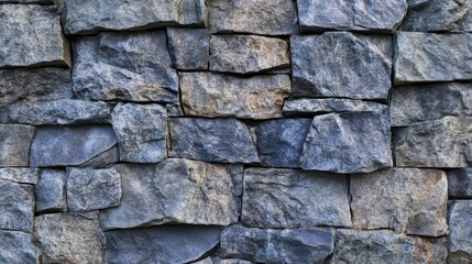 Fototapeta premium Rock wall texture background with irregularly shaped stone blocks suitable for construction, landscaping, home decor, and architectural design projects.