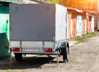 Gray single axle tarpaulin trailer for transporting cargo for a passenger car, copy space for text