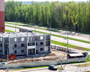 Construction of an apartment building against the backdrop of a forest in the city in summer, industry