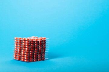 Stack of blisters of tablets on a blue background. Concept of biologically active food supplement, a drug that increases immunity. Copy space for text, anti-inflammatory