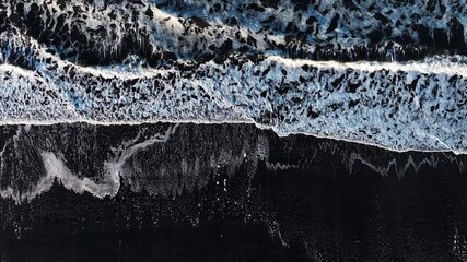 Aerial View of Black Sand Volcanic Beach with Crashing Waves, cinematic long drone shot. Serene and Tranquil Landscape. Iceland.