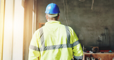 Construction, walking and man with back on site for building inspection, property development or quality assurance. Safety manager, worker or check renovation progress for risk assessment or protocol