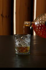 Bartender pouring bourbon whiskey into crystal tumbler glass