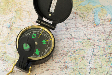 Army compass lies on an old physical map