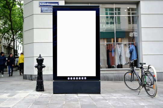 blank digital ad panel. billboard display. empty white lightbox sign on a popular shopping street. mockup template. city transit station. European street setting. outdoor advertising.