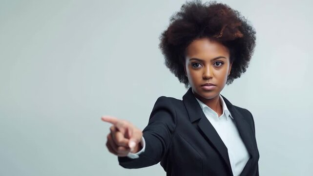 Professional businesswoman pointing decisively toward location on white background, communicating leadership and corporate authority with confident gesture