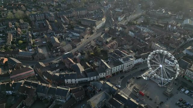 Explore the vibrant charm of Ripon town under the enchanting glow of evening light with a stunning ferris wheel view