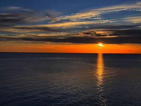 Sundown at sky over dark sea in evening. 