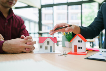 Professional Real Estate Agent Presenting Property Options To Happy Couple