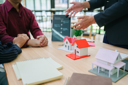 Real estate sales agent explain rental or buying condition to young couple before move to new home or apartment at real estate sales office. Asian urban lifestyle or real estate business concept.
