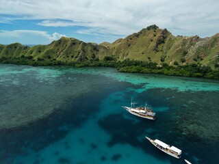 Aerial view A phinisi boat is sailing carrying tourists who will visit the islands around the waters of Labuan Bajo, East Nusa Tenggara, Indonesia.