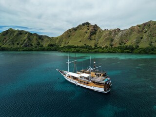 Aerial view A phinisi boat is sailing carrying tourists who will visit the islands around the waters of Labuan Bajo, East Nusa Tenggara, Indonesia.