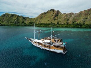 Aerial view A phinisi boat is sailing carrying tourists who will visit the islands around the waters of Labuan Bajo, East Nusa Tenggara, Indonesia.