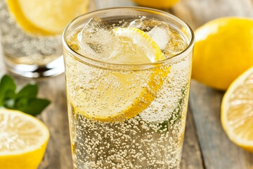 Refreshing iced tea with lemon slices served in a glass on a wooden table in a sunny outdoor setting