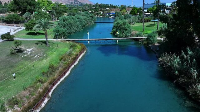 Aerial: Drone Backward Shot Of People Swimming In River At Kibbutz Community On Sunny Day - Nir David, Israel