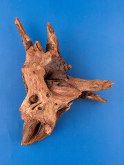 A detailed close-up of natural wooden driftwood, crafted for enhancing aquariums or terrariums, set against a vibrant purple background.