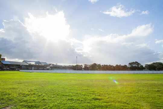 Green grass of empty Newcastle showgrounds with sun flare