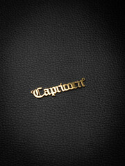 close up gold pendant horoscope with  Capricorn    sign  on a black  background