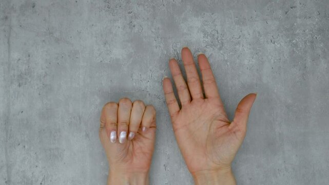 Women's hands take turns showing fingers from one to ten, gestures