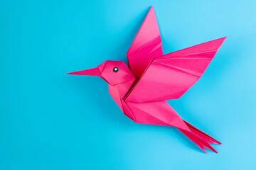 Pink Origami Bird in Flight - A vibrant pink origami bird gracefully takes flight against a bright blue background. A symbol of artistry and creativity