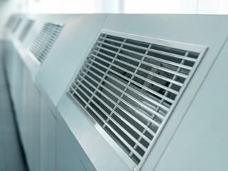 Obraz premium Close-up of a modern air ventilation unit grille in an indoor facility, highlighting industrial airflow system design and climate control infrastructure.