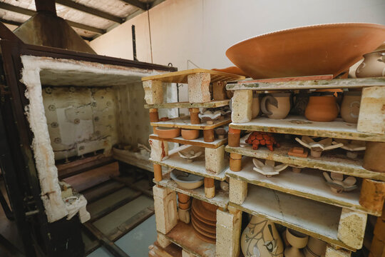 Handcrafted pottery bowls and vases in a spacious workshop awaiting kiln firing