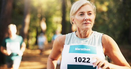 Competition, marathon and running with woman in forest for challenge, performance or race. Action, cardio and fitness with mature runner at rally event in nature or woods for course, heat or trial - obrazy, fototapety, plakaty