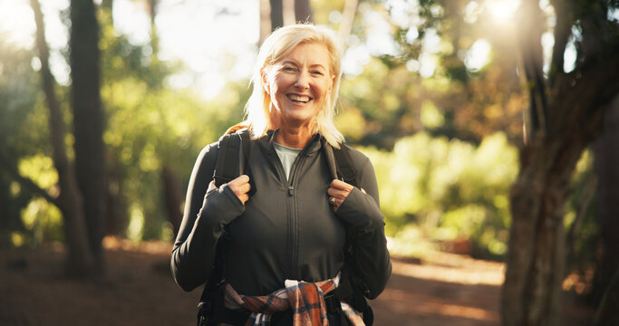 Portrait, senior and happy woman hiking in woods for holiday, travel or vacation on adventure. Smile, trekking and female person in forest for backpacking, tourism or explore nature for hobby in USA