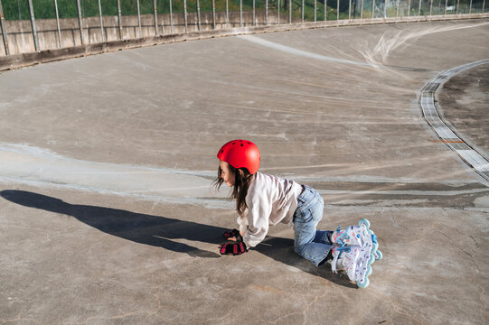Girl learning to roller skate in outdoor skate park