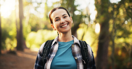 Portrait, travel and happy woman trekking in woods for holiday and vacation on adventure. Smile, hiking and mature female person in forest for backpacking, tourism and explore nature in Switzerland