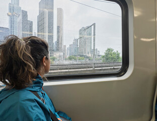 Woman gazing at Melbourne skyline from a train window