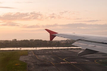 Aircraft landing at sunrise on airport runway