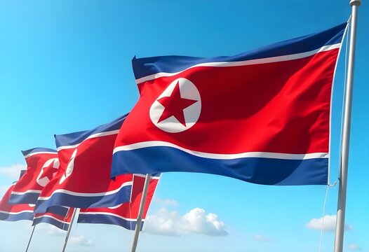 Realistic digital painting of several North Korean flags waving in the wind under a bright blue sky. Each flag features the red field with a white circle and red star, bordered by blue and white strip