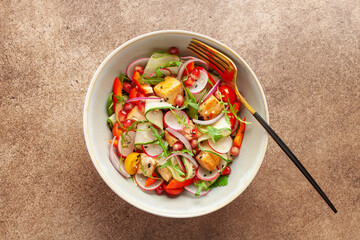 Salad with grilled salmon, fresh green  leaves, cucumber, tomatoes, pepper, radish, pomergranate and red onion . Healthy lunch salad. Top view