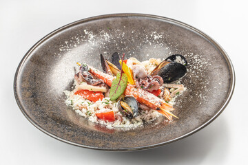 Gourmet seafood risotto with shellfish and grated cheese on an elegant ceramic plate.