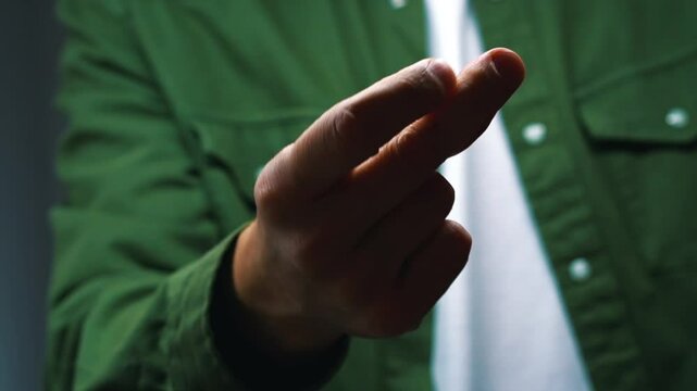 A man in a green shirt snaps his fingers at the camera in slow motion.
Snap of fingers.
Clattering hands. click click.
Sound of fingers.
Finger snapping gesture