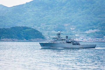 A South Korean navy frigate in grey camouflage returns to base after a coastal patrol mission near the port of Busan – a quiet moment after completing its maritime duty.