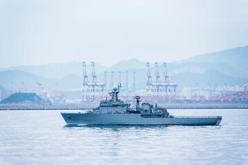 Obraz premium A South Korean navy frigate in grey camouflage returns to base after a coastal patrol mission near the port of Busan – a quiet moment after completing its maritime duty.