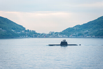 A South Korean submarine cruises along the coastline at sunrise, returning to base after completing...