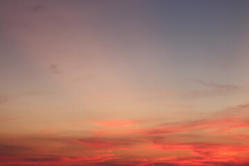 sunset sky blends warm shades of orange, peach, and red with soft purples and lavender tones. Wispy clouds sweep across the horizon, creating a soothing and painterly twilight atmosphere.

