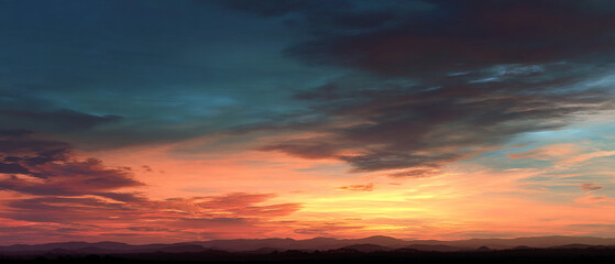 Vibrant sunset sky over mountain silhouette showcasing dramatic colors and atmospheric beauty