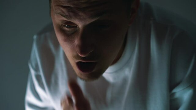 A guy has shortness of breath after active physical activity.
The man is trying to regain his breath.
It is difficult for a person to breathe in a dark room