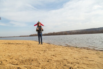 Dad and daughter walking near lake share on sunny day