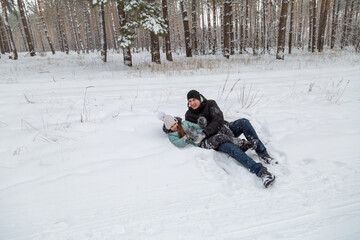 Dad and daughter walking and having fun in snowy winter forest