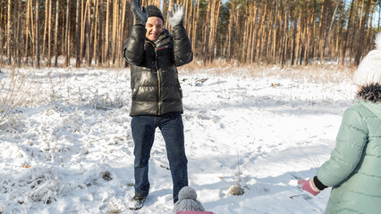 Little girls with her grandfather having fun on snowy winter day