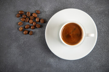 Coffee beans roasted with a cup of Turkish coffee on the gray concrete background