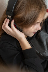 Happy little girl listening music lying on the sofa living-room