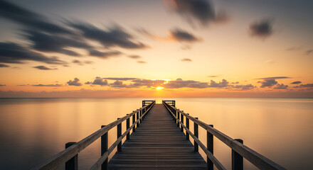 Obraz premium Wooden Pier Extending Towards Sunset Over Calm Reflective Waters