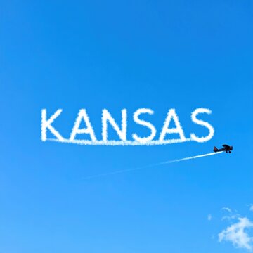 Airplane skywriting 'kansas' against clear blue sky